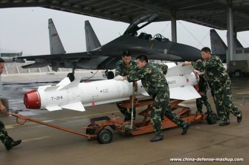 Personel AU Cina tengah mempersiapkan Kh-29TE dengan latar jet Sukhoi Su-30 